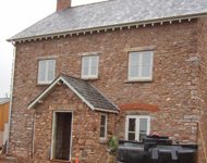 House renovation: Exterior stone walls being cleaned by sandblasting.