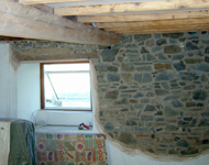 Interior wooden beams being cleaned and stone walls being exposed.