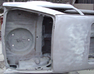 Car body on side during sandblasting.